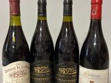 quatre bouteilles de vin sont alignées sur une table