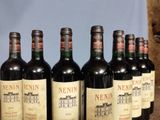 six bottles of wine are lined up in a row on a table