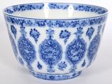 un bol bleu et blanc posé sur une surface blanche