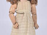 a small doll that is standing on a white surface