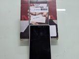 une photo d'un téléphone portable posé sur une table, à côté d'un livre