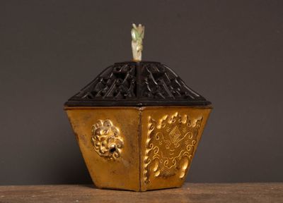 a gold and black box with a bird on top of it