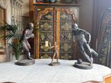two statues of men playing a game of tennis on a table