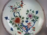 two plates with flowers on them sitting on a table