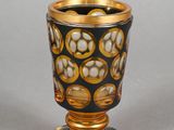 a black and gold vase with a flower design on it