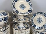 a lot of blue and white plates and bowls on the table