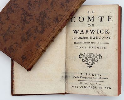 an old book with a brown cover sitting on top of it