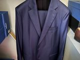 un costume bleu suspendu à un cintre dans une armoire