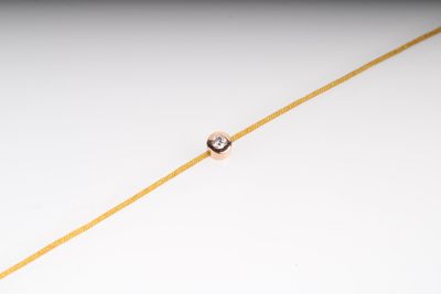 une image représentant un diamant isolé suspendu à une fine chaîne en or