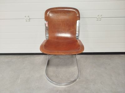 un fauteuil en cuir marron placé devant une porte de garage