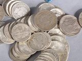 a pile of silver coins and a blue pill on a table