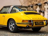 a yellow car that is parked on a cobblestone street