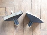 two pieces of metal sitting on a wooden floor