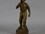 a bronze statue of a man holding a baseball bat on top of a wooden base