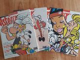 three comics are sitting on a wooden table next to a cup of coffee