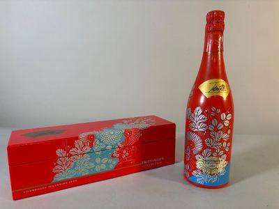 une bouteille de vin à côté d'une boîte sur une table