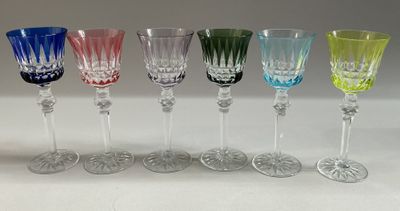 several different colored wine glasses are lined up on a table