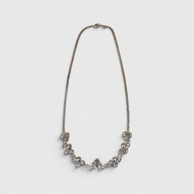 un collier en argent avec des perles et une chaîne sur fond blanc