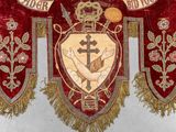 a large red and gold banner with a cross on it