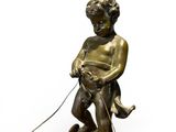 bronze figurine of a boy on a boat with a dog