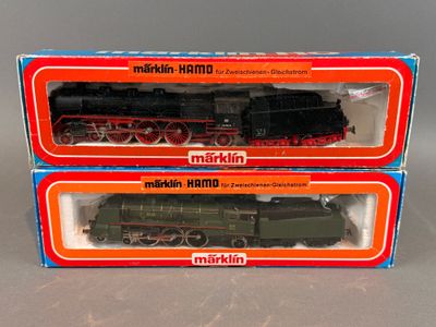 Deux cartons contenant des trains miniatures sont posés sur une table