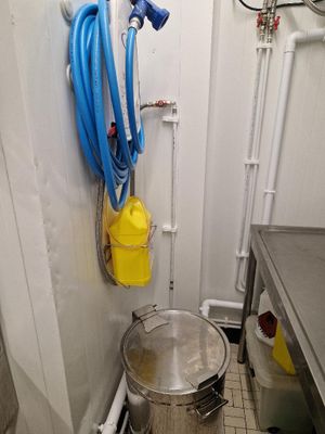une casserole et un tuyau d'arrosage dans une petite pièce
