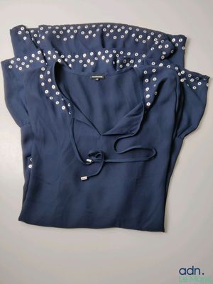 the shirt is blue and has white polka dots on it