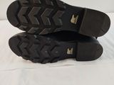the soles of a pair of black shoes on a white surface