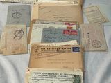 a pile of old letters and envelopes sitting on a bed