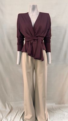 une photo d'un mannequin portant un haut bordeaux et un pantalon beige