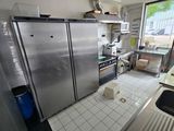 une cuisine équipée d'appareils électroménagers en inox et dotée d'une grande fenêtre