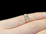 a woman ' s hand holding a ring with a diamond