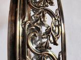 a close up of a silver bracelet on a white surface