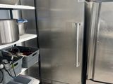 stainless steel refrigerator and freezer in a commercial kitchen with shelves