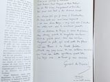 an open book with a handwritten letter on it sitting on a table