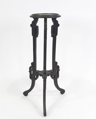 une table en fer noir avec un plateau en verre, sur fond blanc