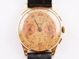 une montre-bracelet en or avec un bracelet en cuir noir