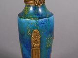 a blue vase with a gold decoration on it