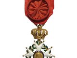 l'image d'une médaille surmontée d'une couronne, suspendue à un ruban rouge