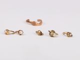 trois paires de boucles d'oreilles en or posées sur un fond blanc