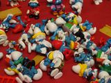a lot of smurfs on a table with a red table cloth
