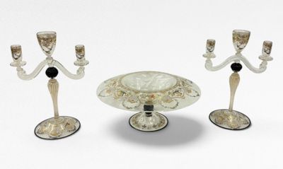 trois bougeoirs en verre et un bol sur la table