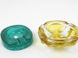 deux objets en verre de couleurs différentes posés sur une surface blanche
