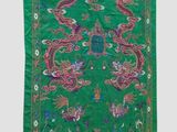 a green rug with a dragon design on it