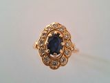 a close up of a gold ring with a sapphire stone