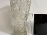 a glass vase and a mug sitting next to each other