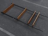 a bed frame on the ground in a parking lot