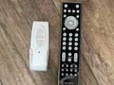 a remote control sitting next to a remote control on a wooden floor