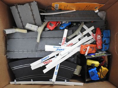 a cardboard box filled with toy cars and other toys