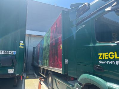 a green truck that is parked in front of a building